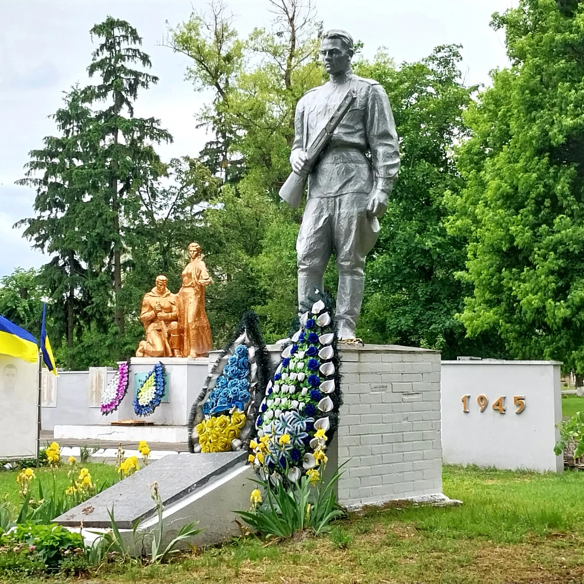 На новой аллее памяти, появившейся на советском мемориале, уже около тридцати портретов с чёрными лентами и столько же сине-жёлтых флагов